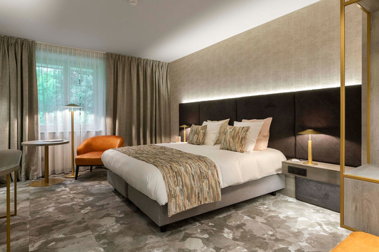 Lit king size et espace détente dans une suite à l’hôtel Van der Valk Waterloo