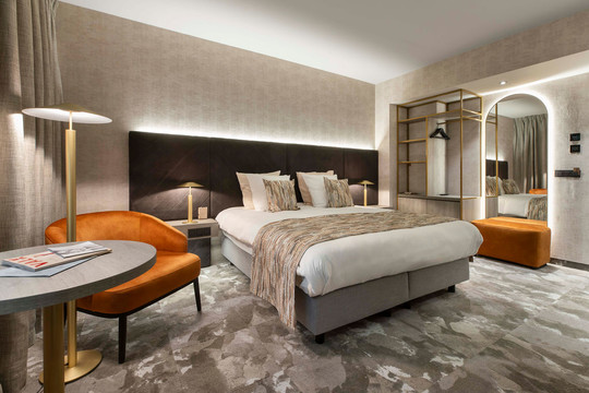 Suite luxueuse de l’hôtel Van der Valk Waterloo avec lit king size et espace bureau